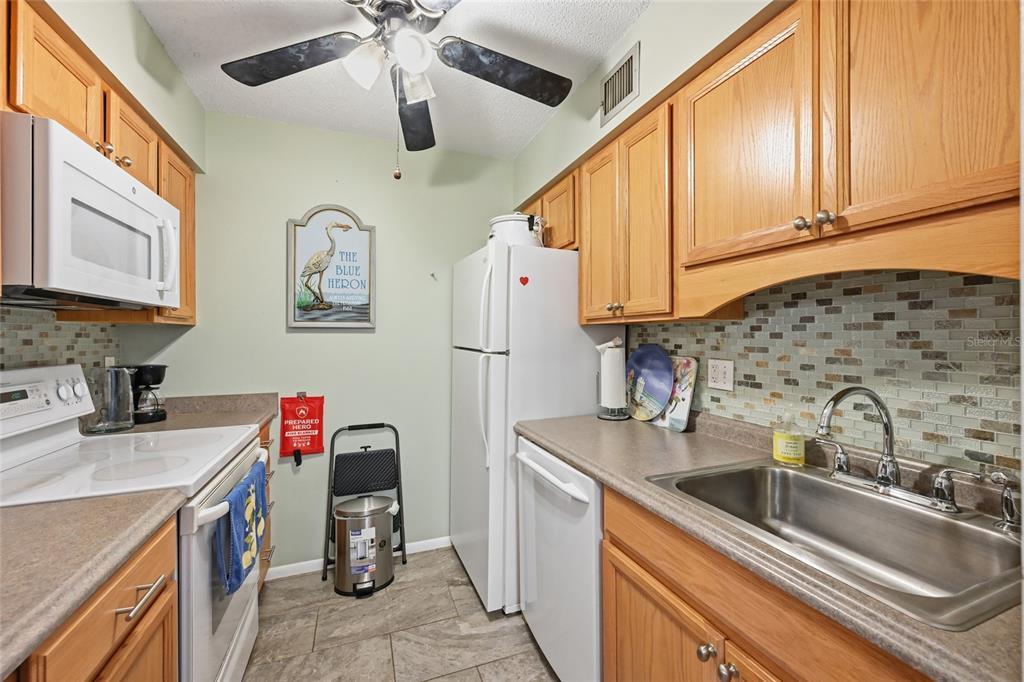 5683 Midnight Pass Road, Unit 110 Sarasota, FL 34242 - Photo 10 of 19 a kitchen with stainless steel appliances sink and cabinets