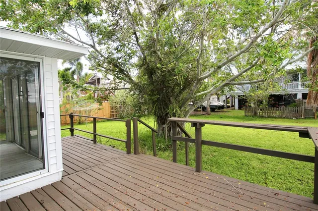 a view of house with deck and a garden