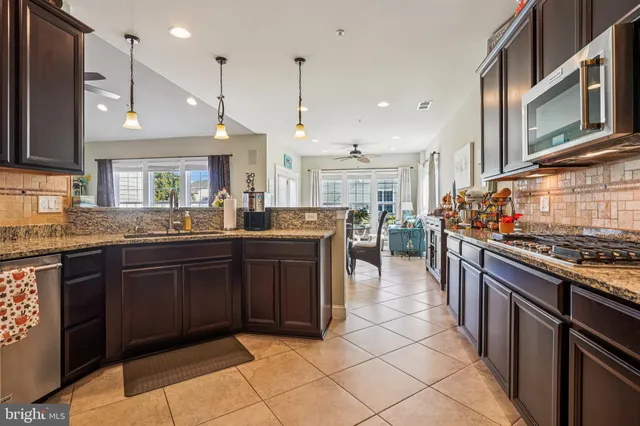 a large kitchen with stainless steel appliances granite countertop a stove and a sink