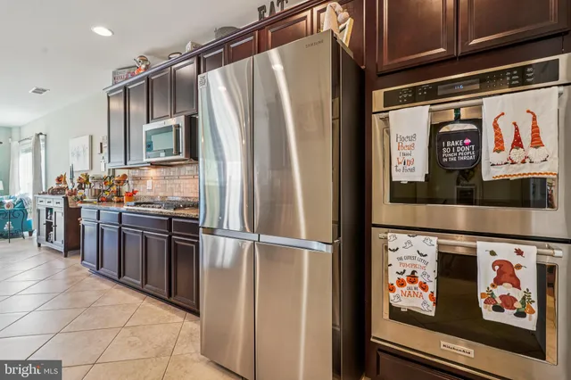 a kitchen with stainless steel appliances granite countertop a refrigerator and a stove