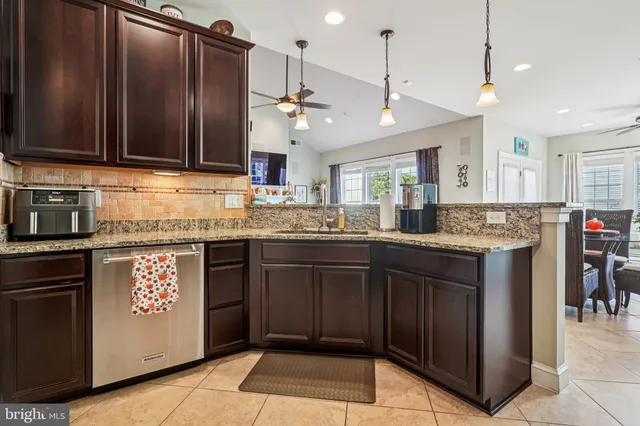 a kitchen with granite countertop a sink stainless steel appliances and cabinets