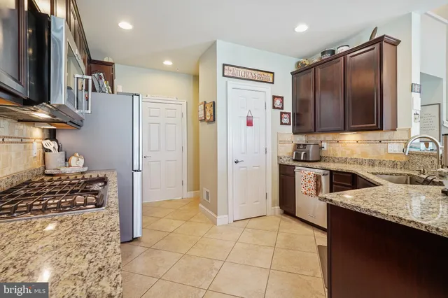a kitchen with kitchen island granite countertop a refrigerator stove and sink