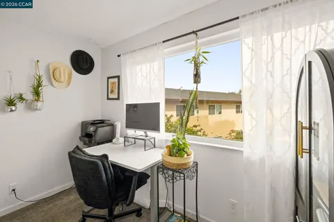 a view of a workspace with furniture and a window