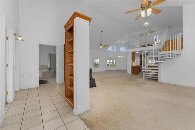 a view of an empty room with wooden floor and furniture