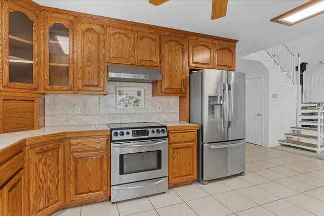 an empty room with windows and ceiling fan