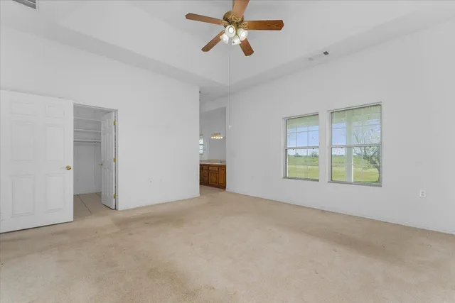a view of a house with a big yard and palm trees