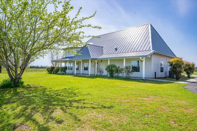 a view of a house with swimming pool and a yard