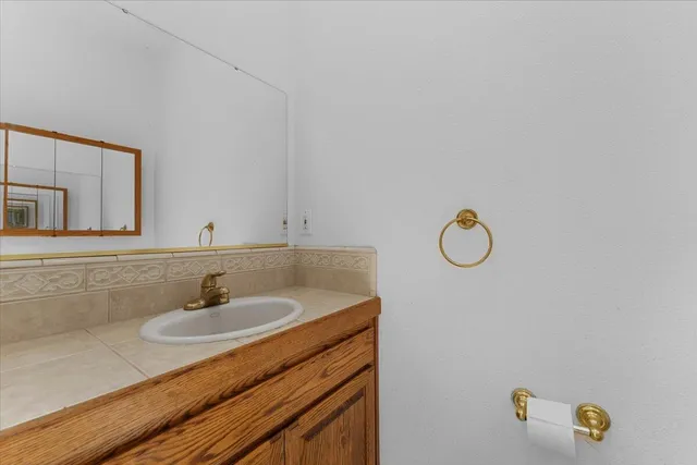 a front view of a building with a garden and trees