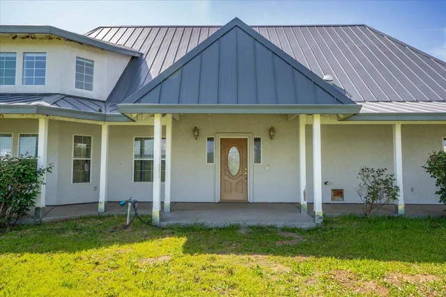 a view of a house with backyard and porch
