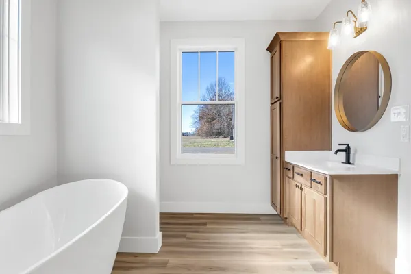 a bathroom with a tub sink and mirror
