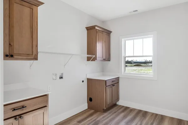 a view of hallway with window and wooden floor