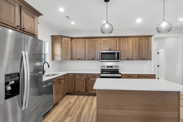 a kitchen with stainless steel appliances a refrigerator sink and microwave