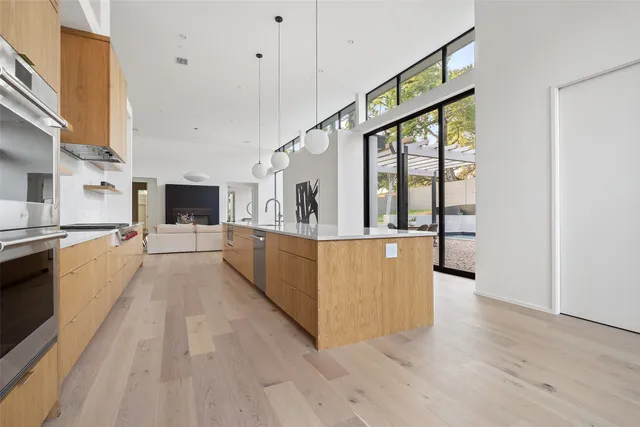 a large white kitchen with cabinets and wooden floor