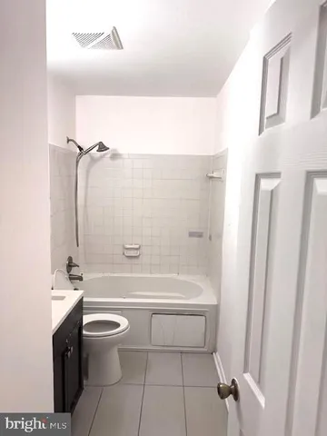 a view of an empty room with chandelier fan and wooden floor