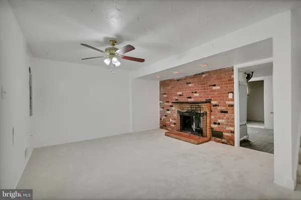 an empty room with fireplace and fan