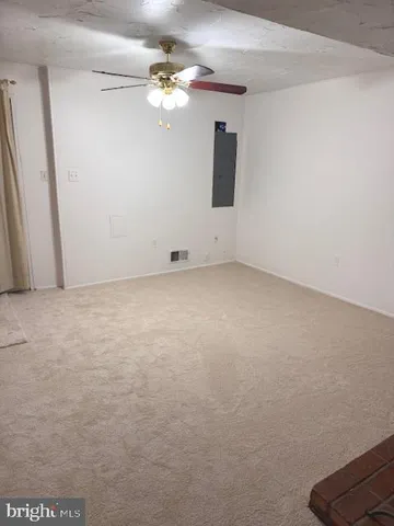 a view of a fireplace with a ceiling fan and fireplace