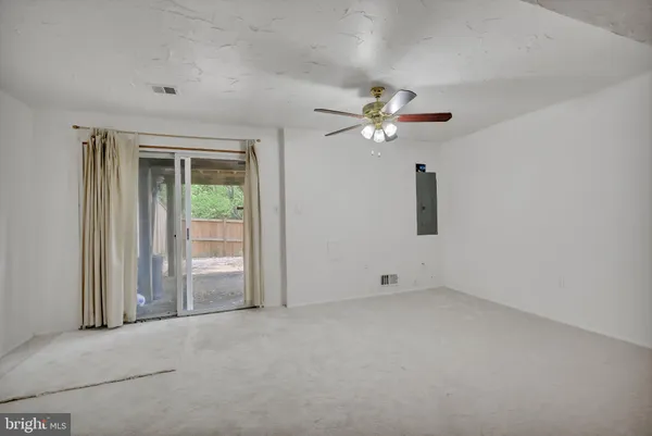 an empty room with a ceiling fan and a window