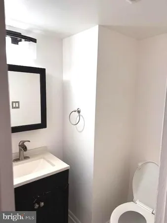 a bathroom with a sink vanity mirror and toilet