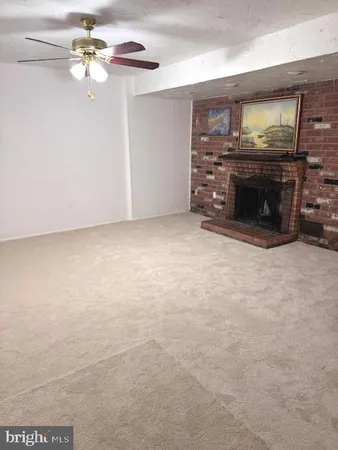 a view of a fireplace with a ceiling fan and fireplace
