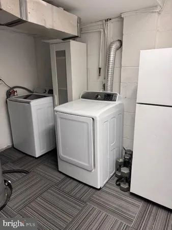 a utility room with cabinets washer and dryer