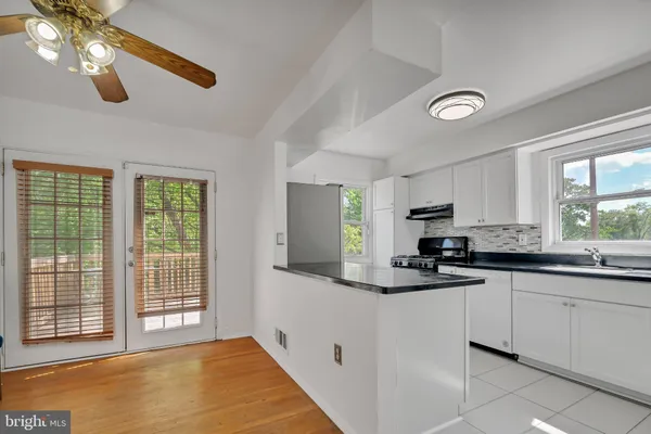 a kitchen with granite countertop a sink window and cabinets
