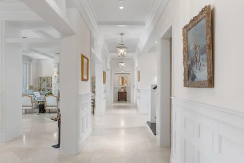 a view of a hallway with wooden floor and a living room