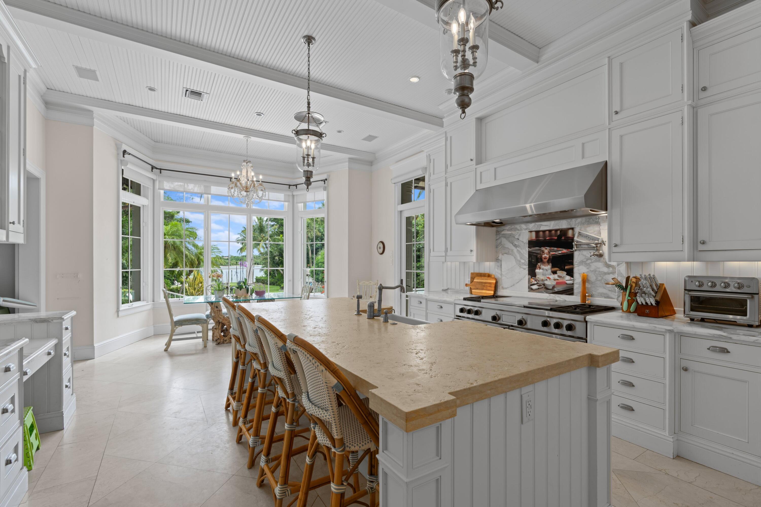 202 Gomez Road Hobe Sound, FL 33455 - Photo 16 of 33 a kitchen with stainless steel appliances granite countertop a stove oven and a refrigerator with white cabinets