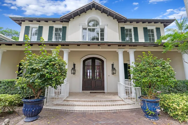front view of a house with a yard and potted plants