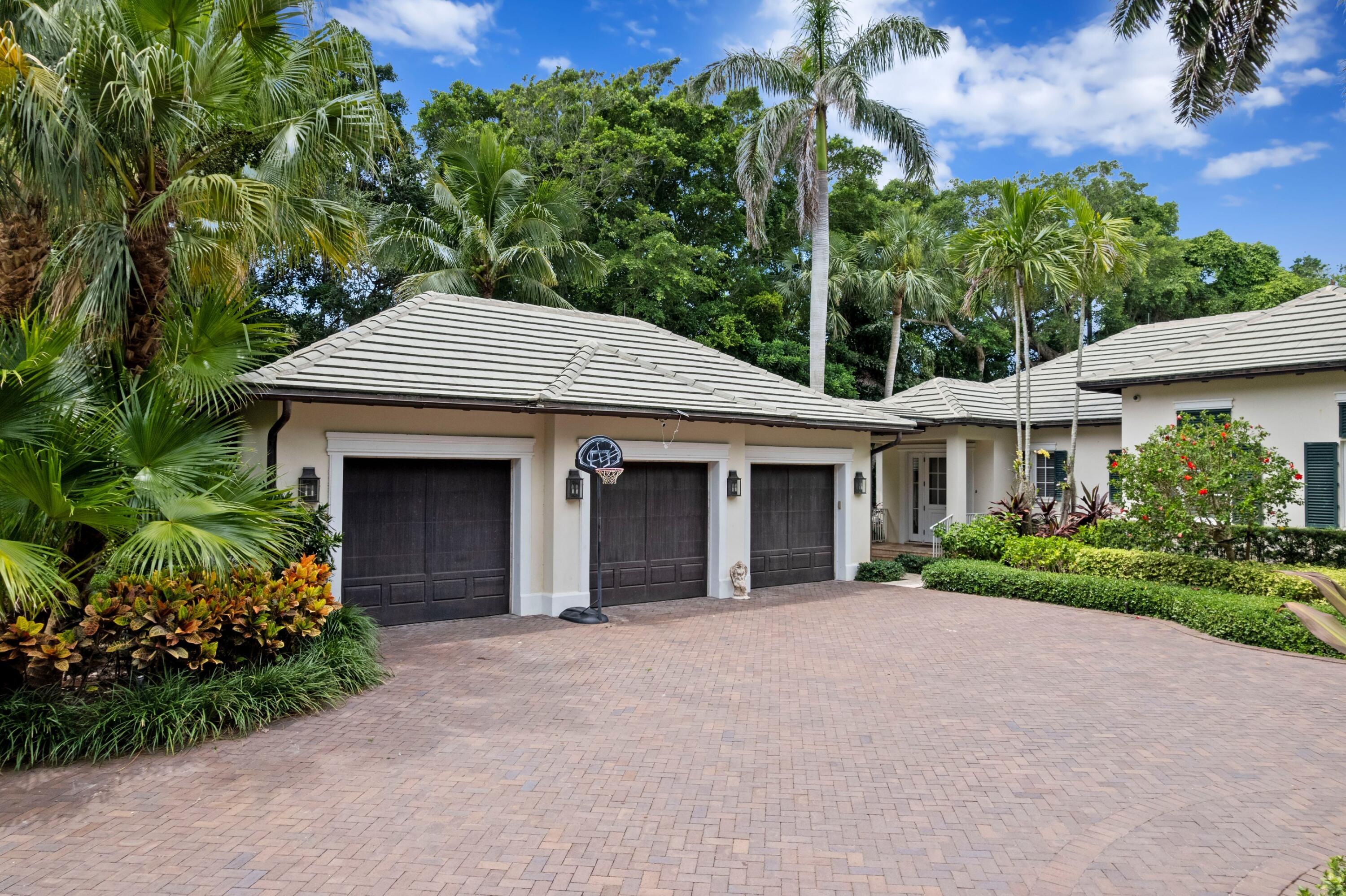202 Gomez Road Hobe Sound, FL 33455 - Photo 24 of 33 front view of a house with a yard and potted plants
