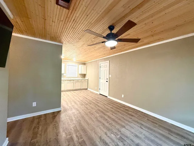 a view of a big room with wooden floor and a ceiling fan