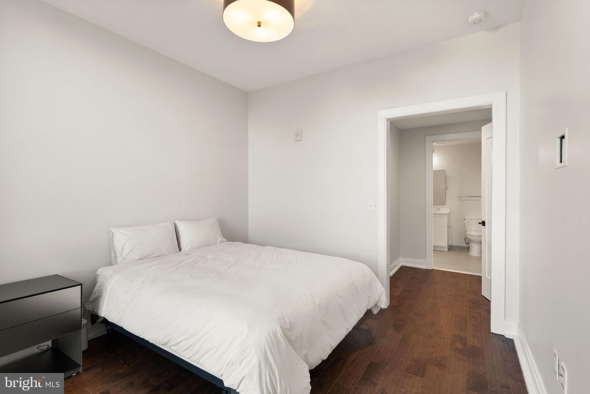 1111 Pennsylvania Ave. Southeast, Unit 304 Washington, DC 20003 - Photo 20 of 42 a bedroom with a bed and a lamp