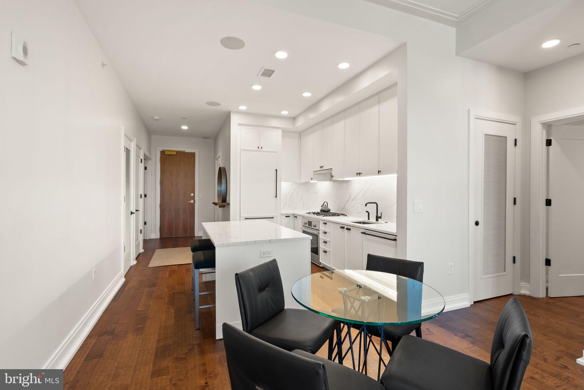 1111 Pennsylvania Ave. Southeast, Unit 304 Washington, DC 20003 - Photo 8 of 42 a living room with stainless steel appliances furniture a rug and a kitchen view