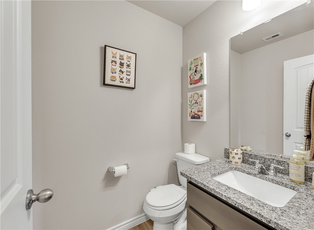 2016 Chief Street Bryan, TX 77807 - Photo 28 of 30 a bathroom with a granite countertop toilet a sink and a mirror