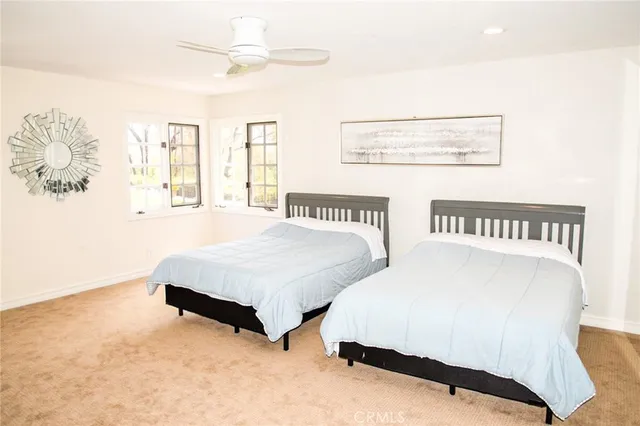 a spacious bedroom with two beds and a large window