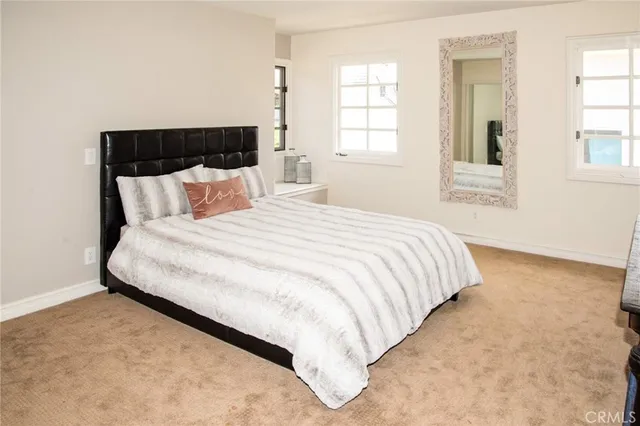 a large bed sitting in a bedroom next to a window