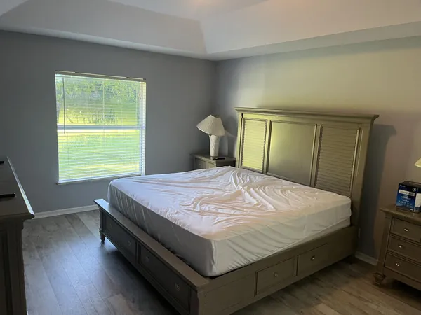 a large bed sitting in a bedroom next to a window