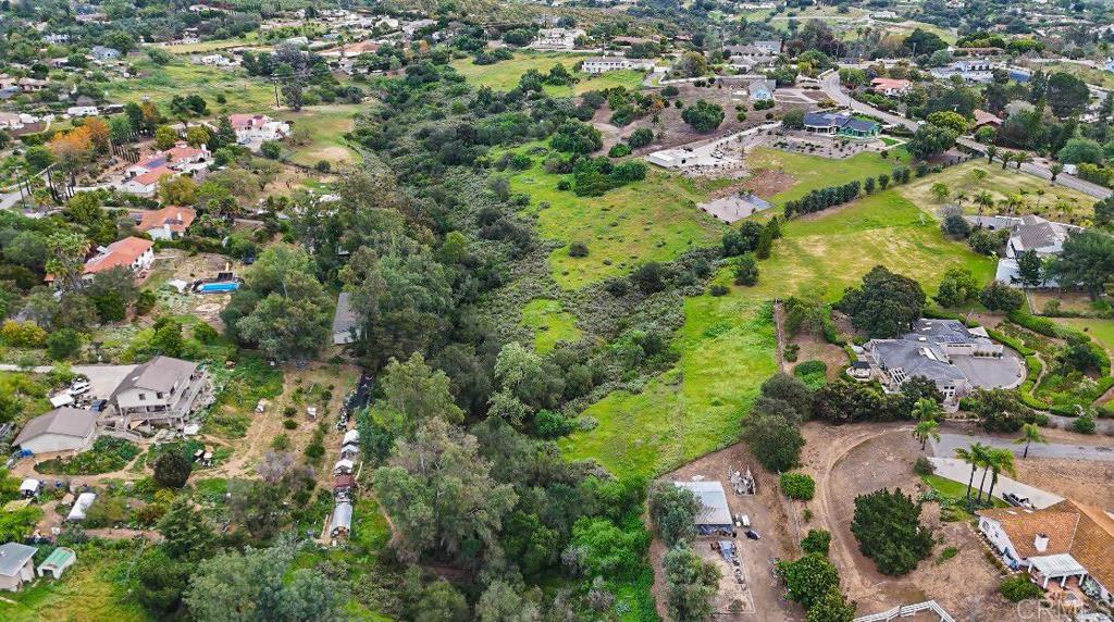 an aerial view of residential houses with outdoor space and trees
