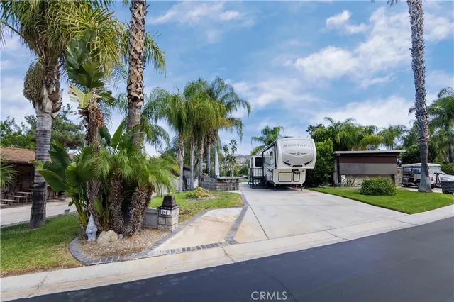 a front view of a house with garden and trees