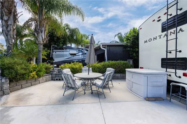 a view of a patio with table and chairs potted plants and palm tree