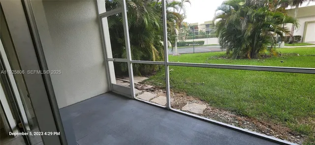 a view of a room with wooden floor and a floor to ceiling window