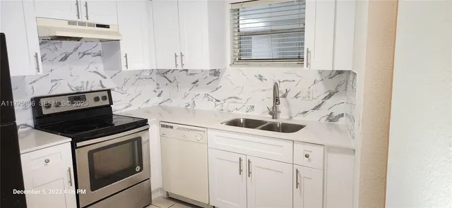 a kitchen with white cabinets and white appliances