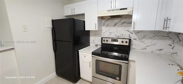 a kitchen with stainless steel appliances wooden cabinets and a stove top oven
