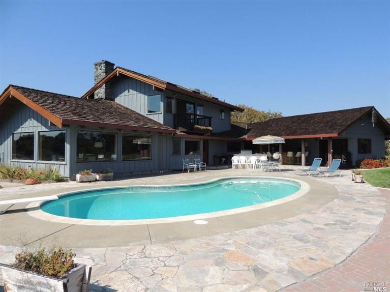 a view of a house with swimming pool and a yard