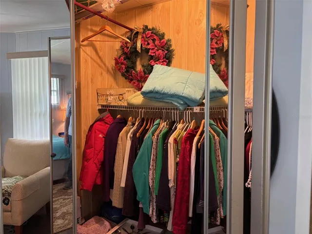 a view of walk in closet with clothes and shoes