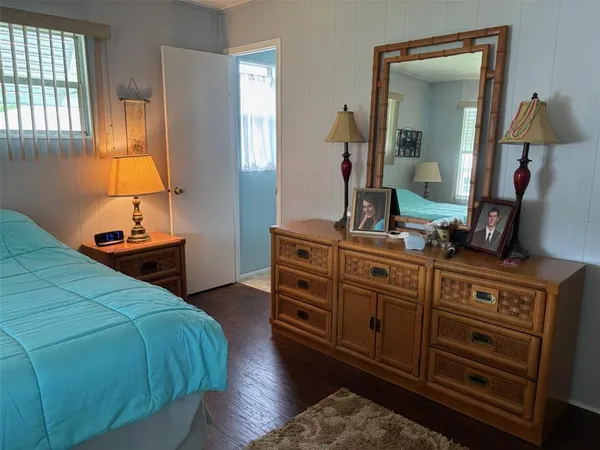 a bedroom with a bed and a mirror on dresser