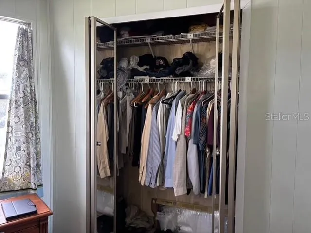 a view of walk in closet with clothes and shoes