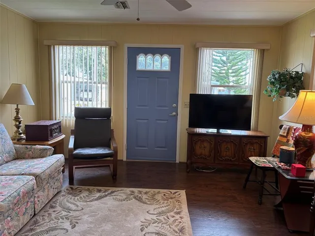 a living room with furniture a flat screen tv and a window