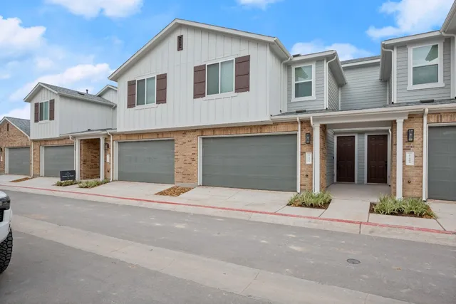 a front view of a house with a yard and a garage