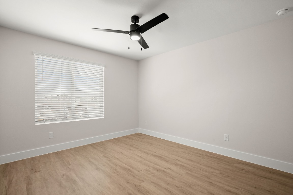 17407 Homestead Haven Drive Bee Cave, TX 78738 - Photo 11 of 16 an empty room with wooden floor fan and windows