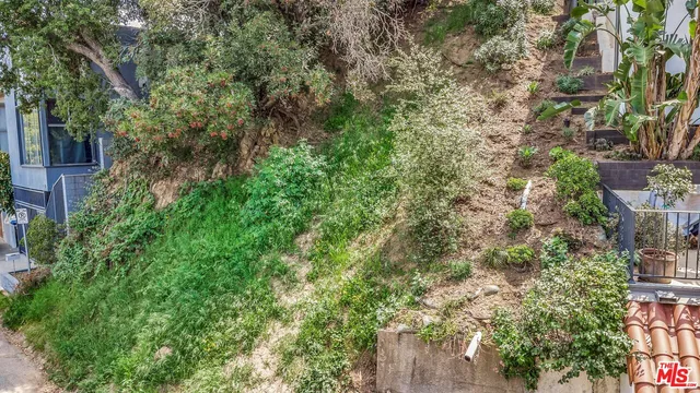 an aerial view of residential house with outdoor space and trees all around